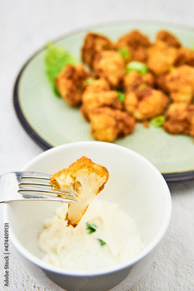 Vegan cauliflower buffalo wings on a fork. Tasty vegetarian food close up. crispy fried cauliflower bites Vegan cauliflower buffalo wings on a fork. Tasty vegetarian food close up. crispy fried cauliflower bites