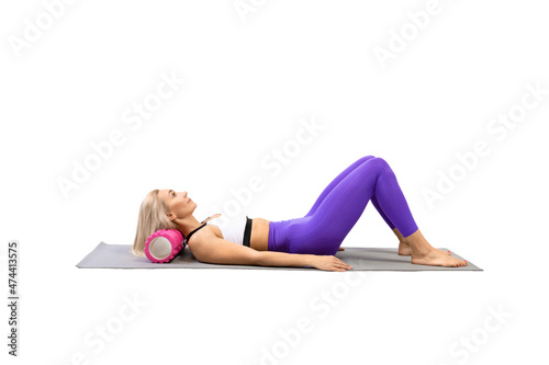 Neck and trapezius muscles extension. Adult fit woman lying on back and using pilates roller to stretch her muscle, isolated on white.
