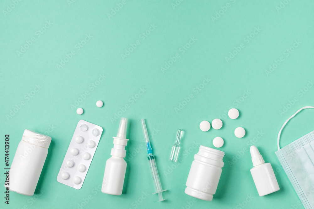 Medical concept, flat, lying on a green background. Space for copying. Pills, nasal spray, drops, syringe on green, top view Medical concept, flat, lying on a green background. Space for copying. Pills, nasal spray, drops, syringe on green, top view