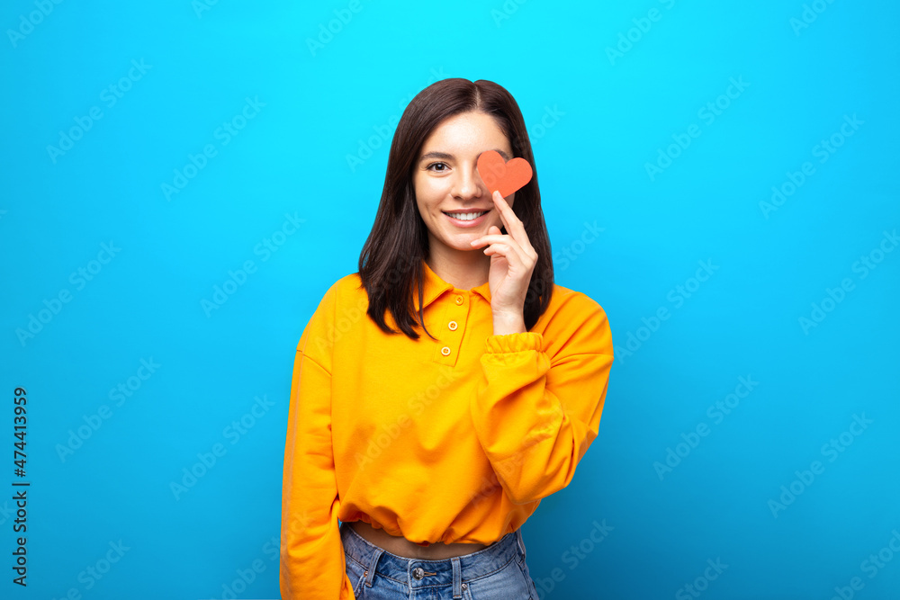amazing mixed races woman with beautiful smile holding a heart shape valentine over eye amazing mixed races woman with beautiful smile holding a heart shape valentine over eye
