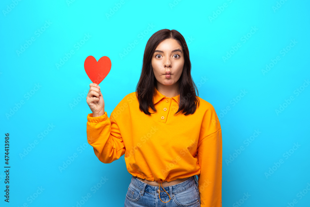 amazing mixed races woman with funny face holding up big heart-shaped valentine amazing mixed races woman with funny face holding up big heart-shaped valentine