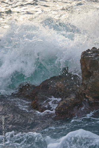 the wave breaks on the rock
