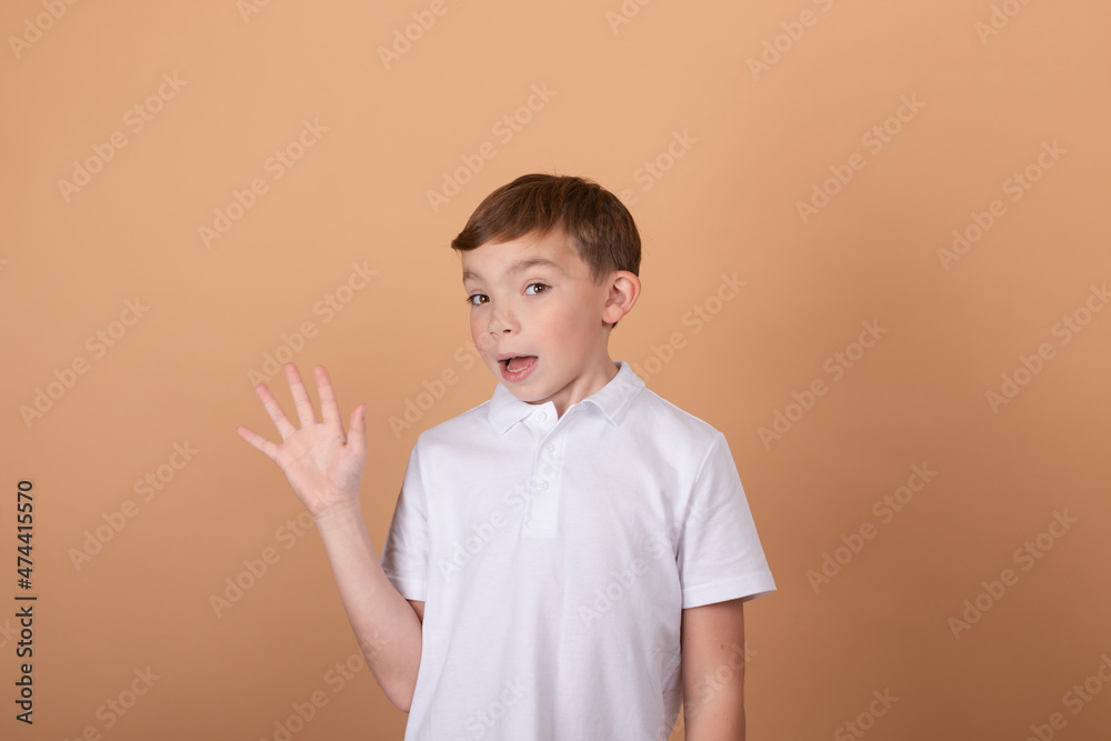 Portrait of school boy with facial expression isolated over light brown background. Concept of feelings, youth, fashion, facial expression, emotions, lifestyle, ad.