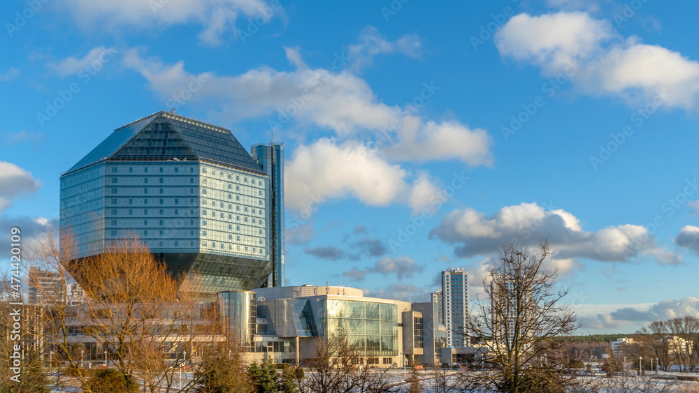 Landscape with modern National library building in Belarus on classic blue sky with clouds background. Space for text.