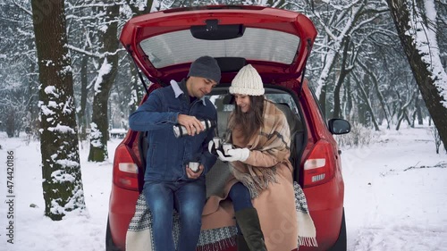 Tea party in car trunk - loving couple sits in car trunk