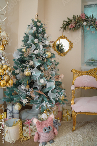 Wallpaper Mural Beautiful fir tree decorated with baubles, garlands, stuffed toy owl and presents under it. Golden mirror on wall, pink sofa. Merry Christmas Torontodigital.ca