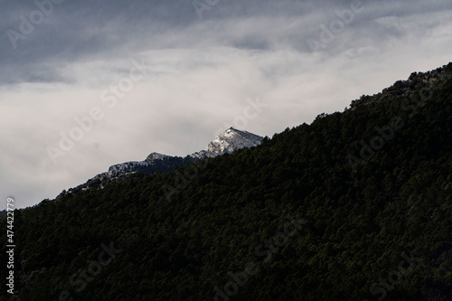 Snowy mountain with clouds at sunset