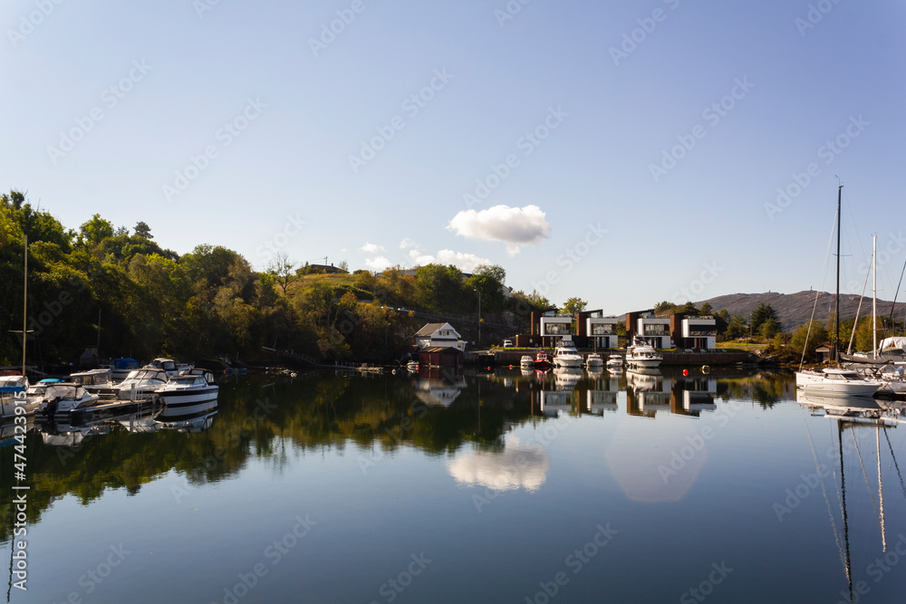 Yachts and houses reflected on calming water. Lifestyle in Norway