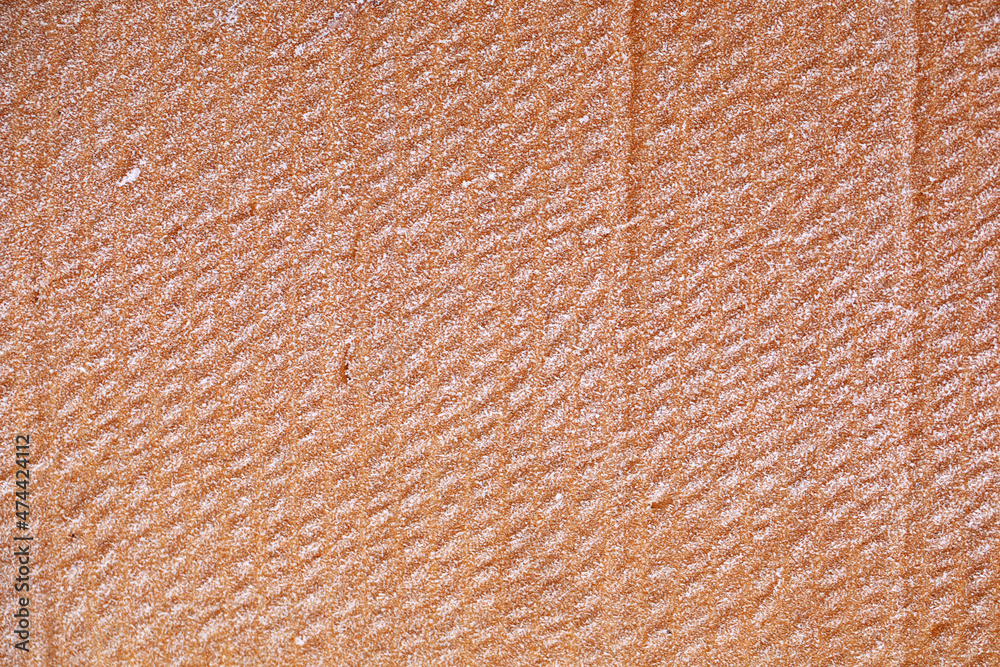 Fototapeta premium The texture of the wet yellow cardboard is covered with frost.
