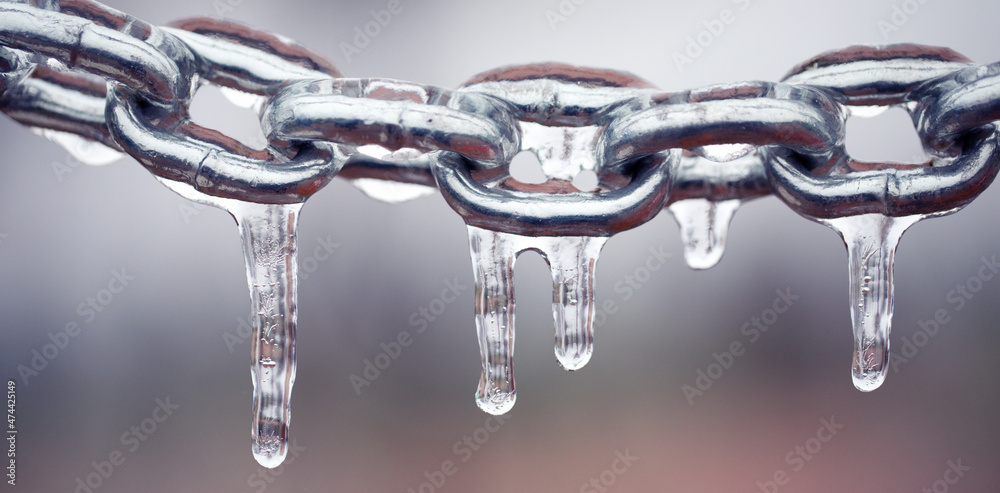 Icicles on a chain, frosted metal on a light background. Icicles on a chain, frosted metal on a light background.