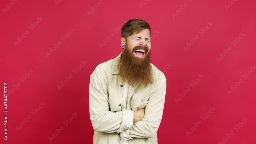 Redhead man with long beard keeping the arms crossed while smiling over isolated background