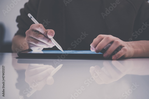 Teenager drawing with tablet and virtual pen. Millennial student doing homework with new technology devices. Young boy draw on pad at home. Male hands working with digital pencil on the touch screen.