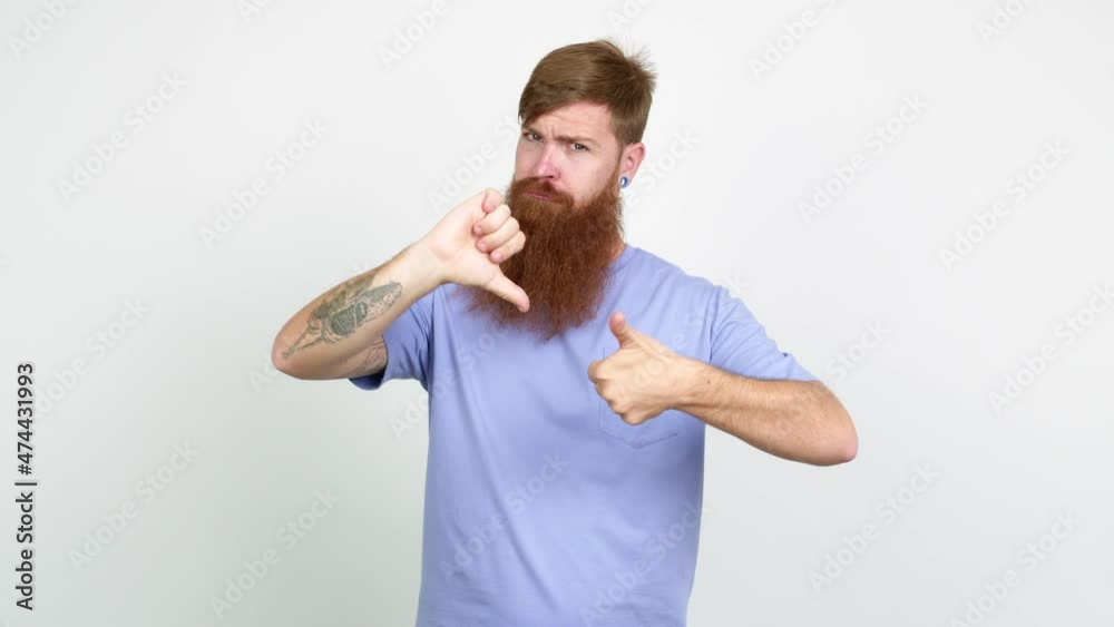 Redhead man with long beard making good-bad sign over isolated background Redhead man with long beard making good-bad sign over isolated background