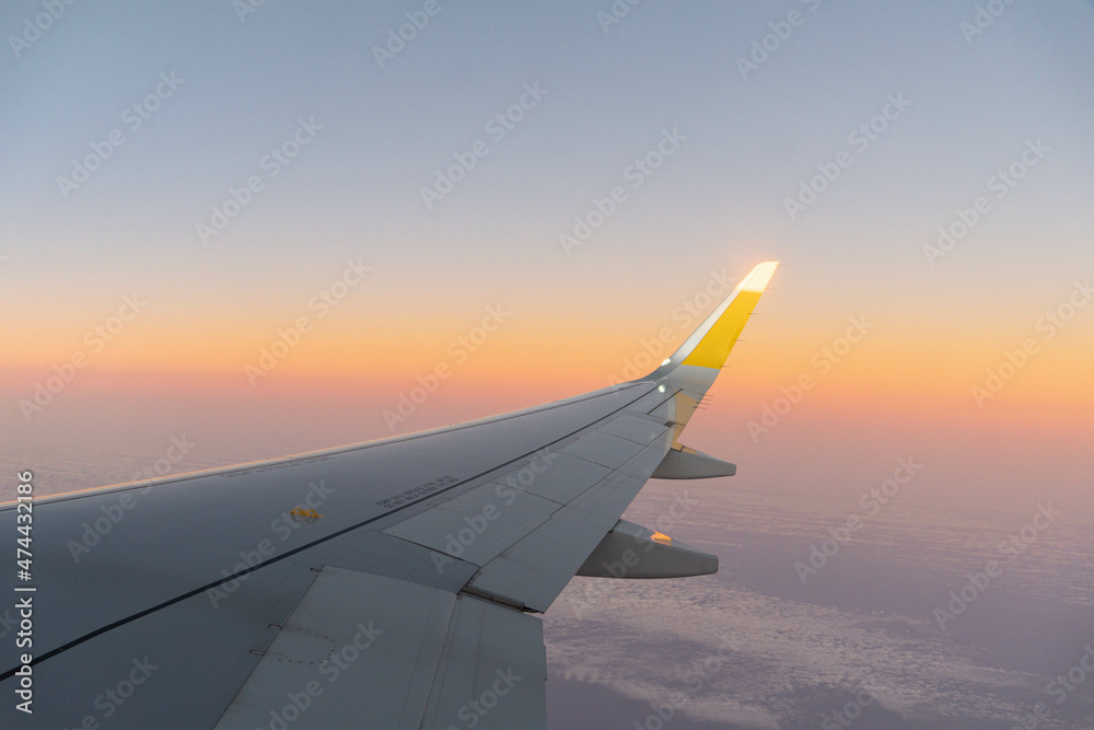 Ala de avión de pasajeros en el aire con luz de atardecer Ala de avión de pasajeros en el aire con luz de atardecer