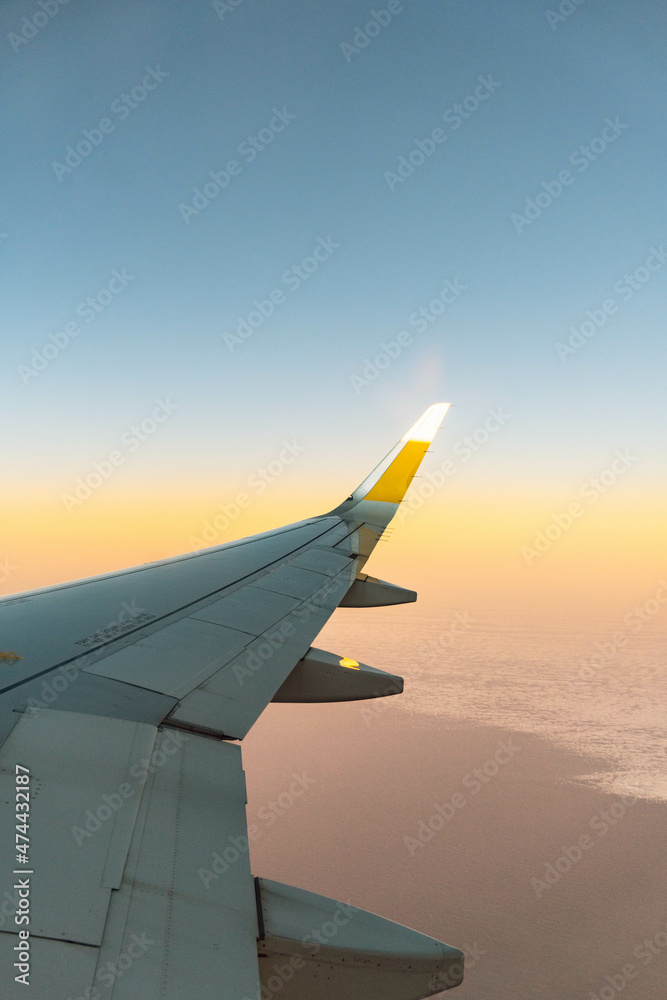 Fotografía de un ala de un avión con una franja amarilla. Fotografía de un ala de un avión con una franja amarilla.