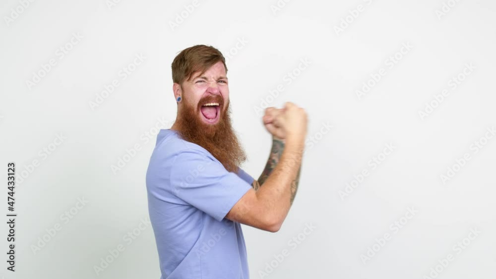 Redhead man with long beard celebrating a victory over isolated background Redhead man with long beard celebrating a victory over isolated background