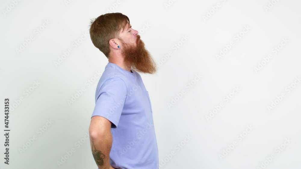Redhead man with long beard looking side over isolated background Redhead man with long beard looking side over isolated background