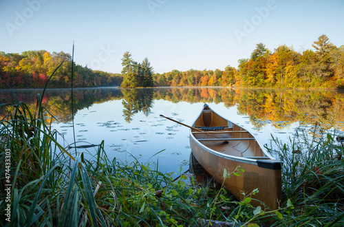 Canoe with paddle on shore of beautiful lake with island in northern Minnesota a Fototapet