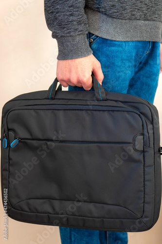 close-up. bag in hand, guy holds a laptop bag in his hands, a protective folder for a laptop.