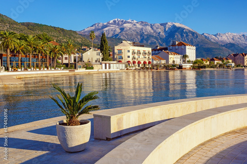 Beautiful Mediterranean landscape on sunny winter day. Montenegro, embankment of city of Tivat. View of Bay of Kotor and snow-capped Lovcen mountain photo