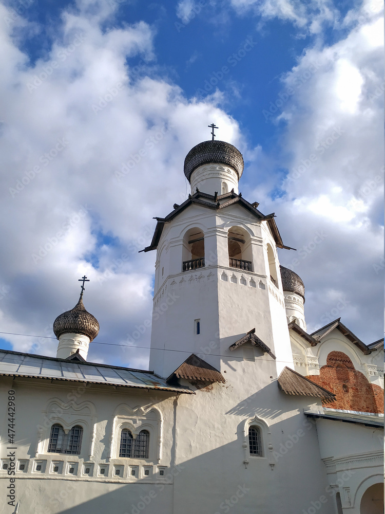 The restored white-stone bell tower of the monastery in the Old Russian architectural style rises in the center of the ancient city of Staraya Russa, Novgorod region. The restored white-stone bell tower of the monastery in the Old Russian architectural style rises in the center of the ancient city of Staraya Russa, Novgorod region.