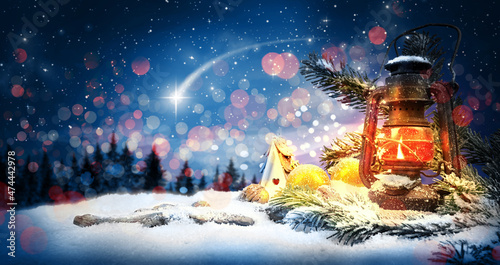 Christmas Schein der Laterne in der Winter Landschaft bei Nacht zu Weihnachten mit dem leuchtenden Stern von Bethlehem und Christbaum Kugeln sowie Tannenzweige im Schnee. 