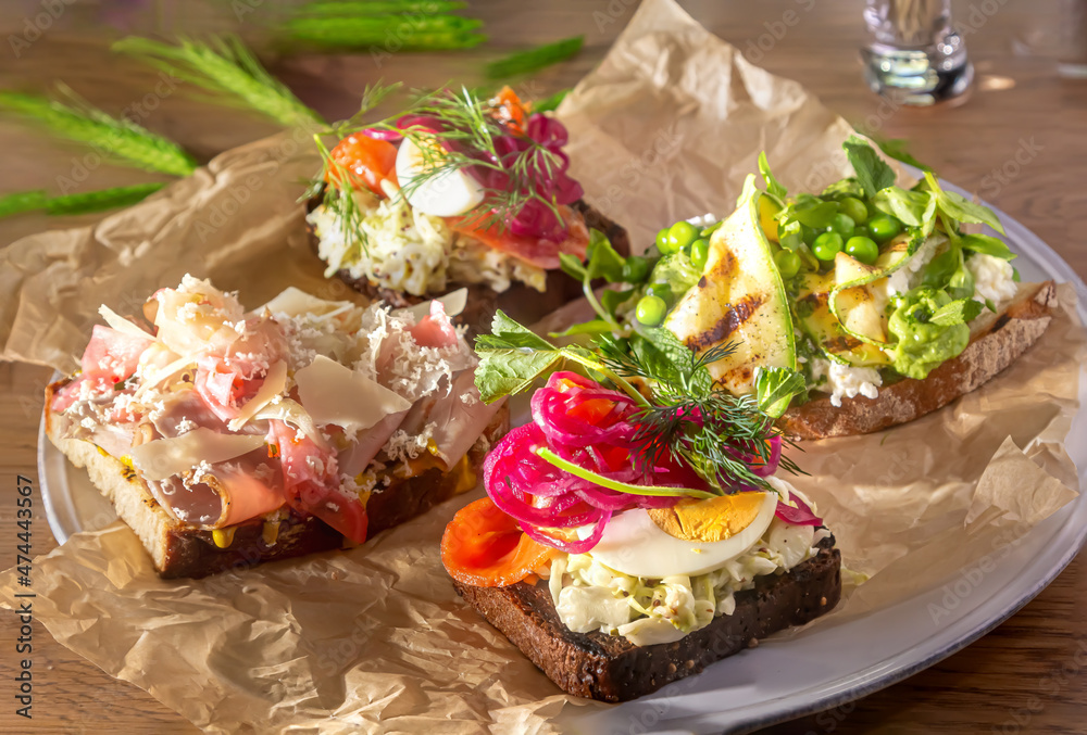 Traditional Danish sandwiches, Smorrebrod with salted salmon, pickled onions, vegetables, green peas and bacon Traditional Danish sandwiches, Smorrebrod with salted salmon, pickled onions, vegetables, green peas and bacon