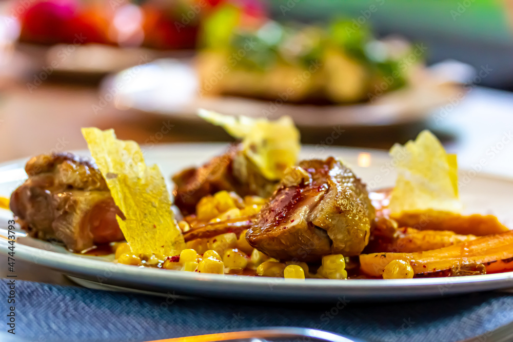 Stewed duck breast with vegetables and corn is on a plate. Stewed duck breast with vegetables and corn is on a plate.