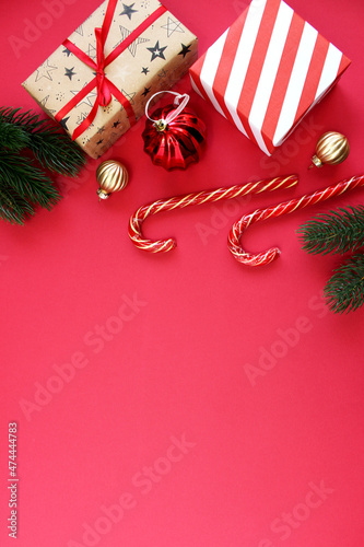 Christmas composition. boxes as gift on branch fir tree on red backgraund. Top view, copy space