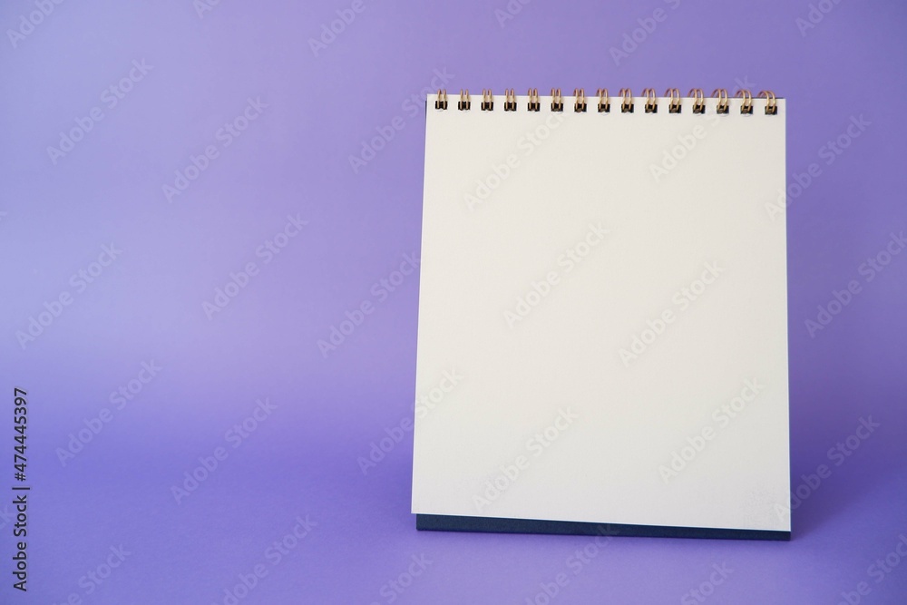 A paper white calendar stands on the table. Mock Up Vector Template. Blank Calendar on purple background. A paper white calendar stands on the table. Mock Up Vector Template. Blank Calendar on purple background.