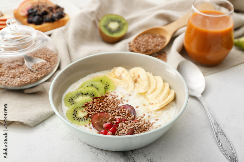 Tasty yoghurt with fruits and flax seeds in bowl on table