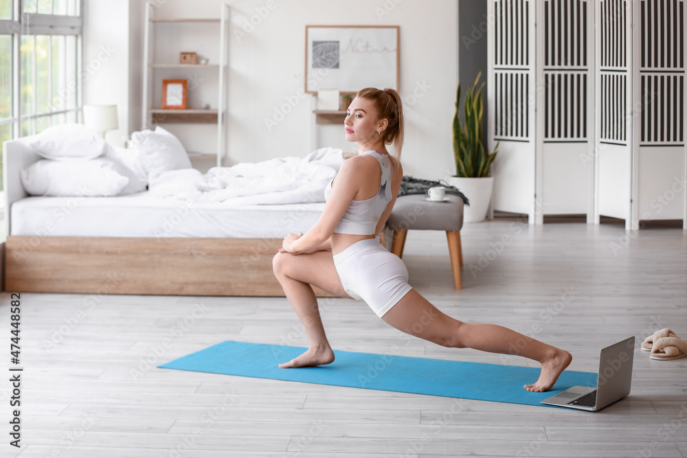 Pretty young woman practicing yoga at home in morning Pretty young woman practicing yoga at home in morning