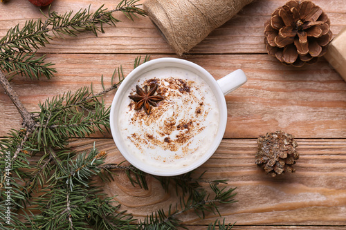 Fototapeta Naklejka Na Ścianę i Meble -  Cup of tasty coffee with cinnamon, pine cones and fir branch on wooden background