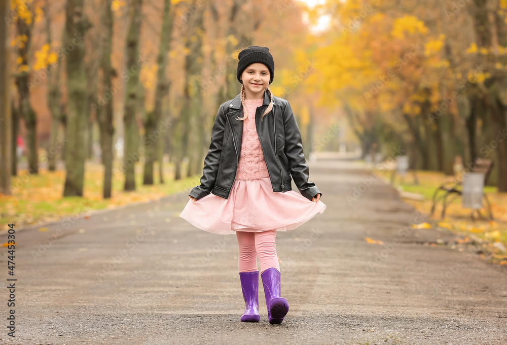 Little girl in stylish rubber boots walking in autumn park Little girl in stylish rubber boots walking in autumn park