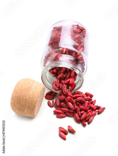 Glass jar with dried barberry on white background