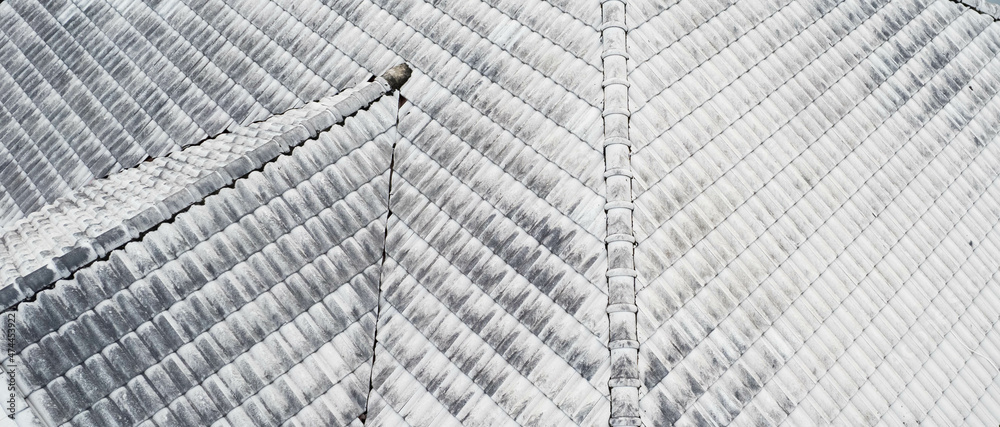 Obraz premium Close up top view of white gray roof tiles.Old dirty and clean roof. Modern roof tiles houseware. Construction equipment build a house.fix problem home,Rain damage to fix roof tiles.