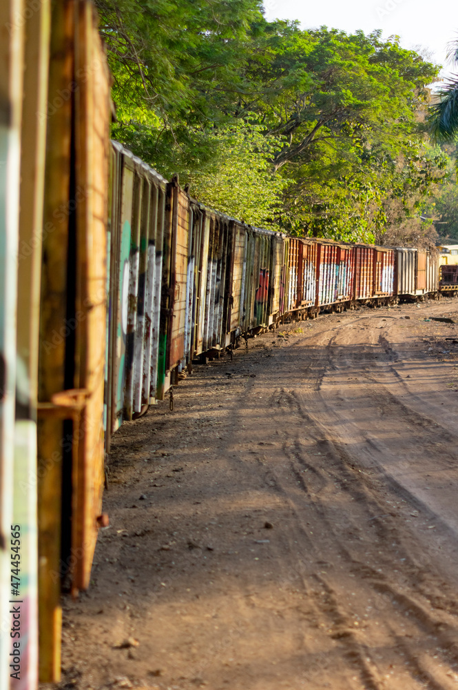 Old colorfully painted abandoned train carriages illuminated by sunset Old colorfully painted abandoned train carriages illuminated by sunset