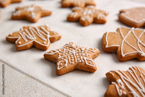 Parchment with sweet Christmas gingerbread cookies on light background, closeup