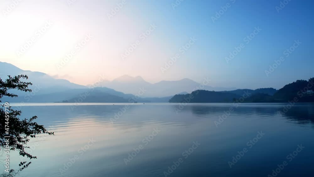 Panning shot from left to right of the looming mountains and calm sea Panning shot from left to right of the looming mountains and calm sea