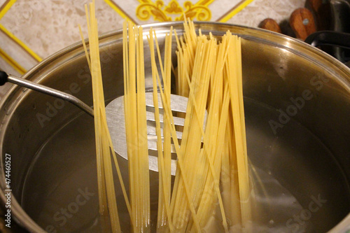 spaghetti pasta to cook in a saucepan of a restaurant in the kitchen
