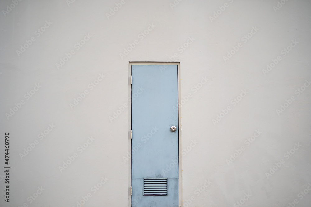 White closed door on white background. Frame on grey wall in the empty room. White closed door on white background. Frame on grey wall in the empty room.