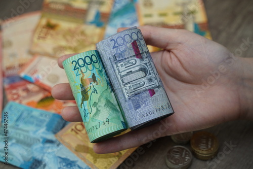 Almaty, Kazakhstan - 12.02.2021 : Banknotes of Kazakhstani tenge are folded into a roll