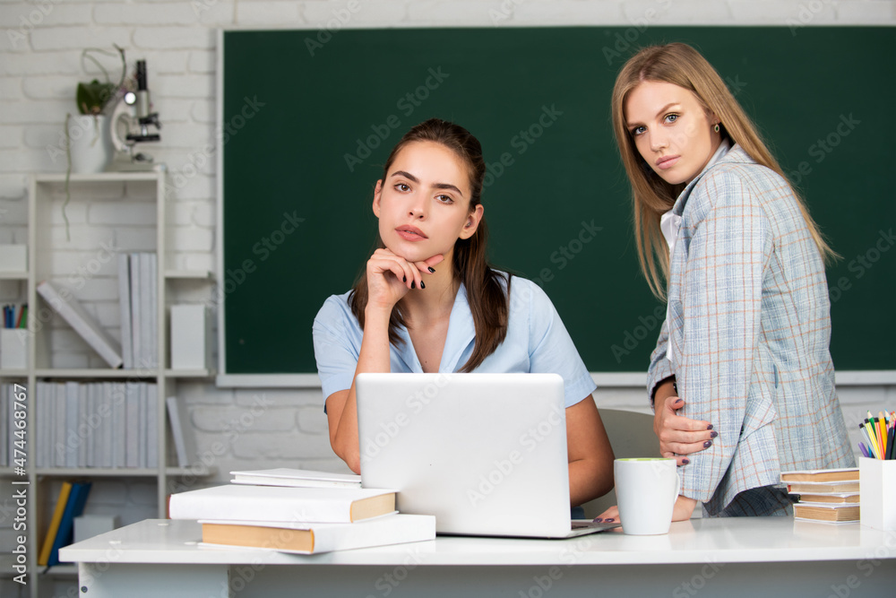 Students girls friends in classroom at school college or university on blackboard background. Learning and preparing for exam with friends. Students girls friends in classroom at school college or university on blackboard background. Learning and preparing for exam with friends.