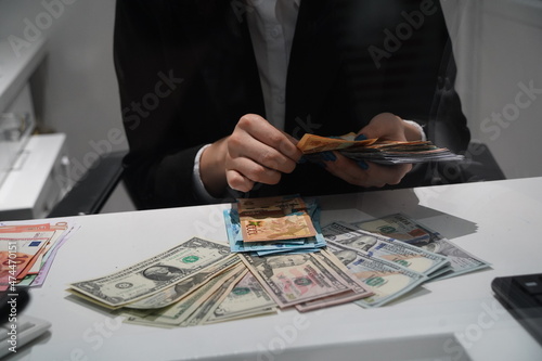 Almaty, Kazakhstan - 11.16.2021 : The bank's cashier recalculates banknotes of different denominations before the exchange photo