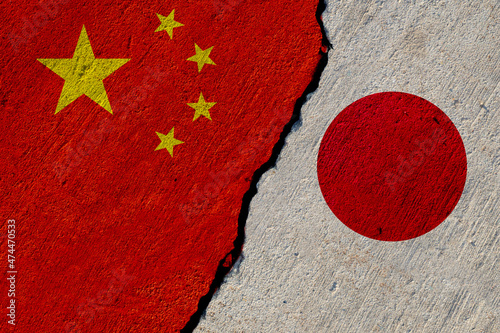 Photography chinese and japan flags painted on cracked concrete wall, china and japan confli