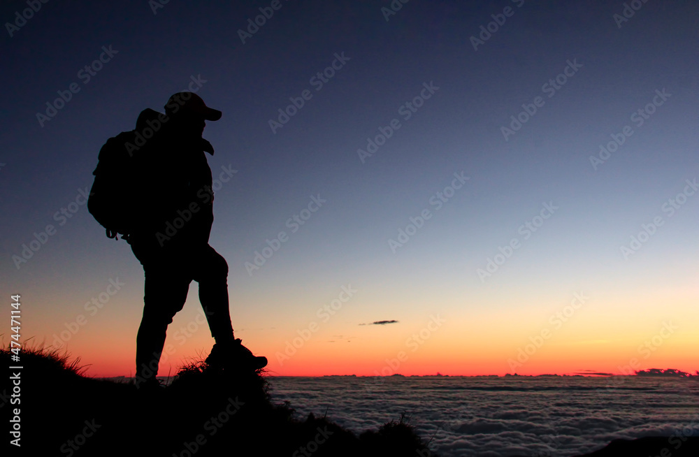 Silhouette of Hiker in the Mountain with a Sea of Clouds Silhouette of Hiker in the Mountain with a Sea of Clouds