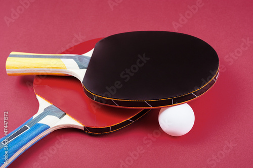 Pair of red ping-pong rackets and white ball, isolated on white background