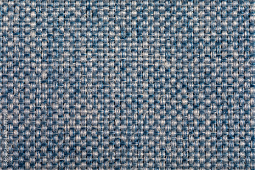 Blue fabric texture. Furniture upholstery textiles. Embossed pattern. Woven fibers. The material is soft touch. Minimalism concept. High detail macro photography for backgrounds or wallpapers.