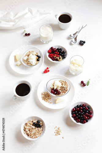 Healthy breakfast. Muesli with berries, yogurt with fruits and drinks on a white table. 