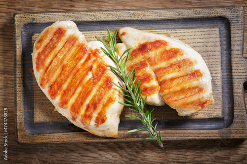 grilled chicken with rosemary on a wooden board